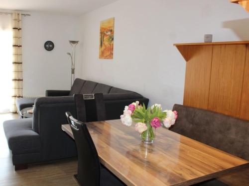 a living room with a table with a vase of flowers at Ferienhaus Nr 57, Kategorie Königscard, Feriendorf Hochbergle, Allgäu in Bichel