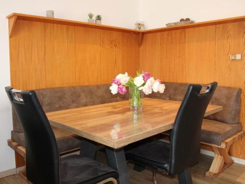 a dining room table with a vase of flowers on it at Ferienhaus Nr 57, Kategorie Königscard, Feriendorf Hochbergle, Allgäu in Bichel
