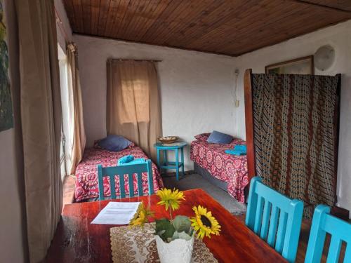 Cette chambre comprend 2 lits et une table fleurie. dans l'établissement Sea view, self-catering, vacation apartment., à Elysium