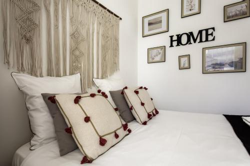 a bedroom with a white bed with a home sign on the wall at Grand T3 rue piétonne bureau et terrasse in Angoulême