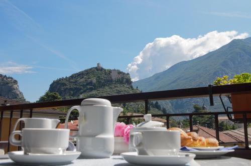 a table with coffee cups and donuts on a balcony with mountains at Active Living Residence - Self Check-In in Arco