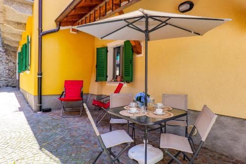 a table and chairs with an umbrella on a patio at Appartamento Gloria in Cannobio