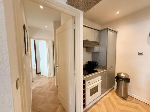 une petite cuisine avec une porte s'ouvrant sur un couloir dans l'établissement A025-Appartement 2 chambres - carré d'Or-hyper centre Cannes, à Cannes