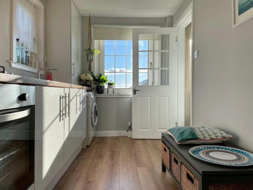 a kitchen with a sink and a door with a window at A 2 Bedroom flat in Culross home of Outlander in Culross
