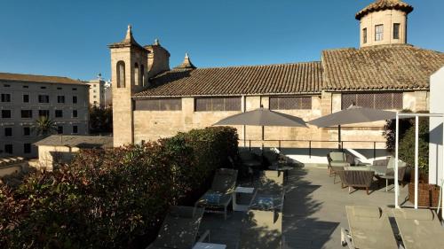 a patio with chairs and umbrellas in front of a building at Sant Jaume Design Hotel in Palma de Mallorca