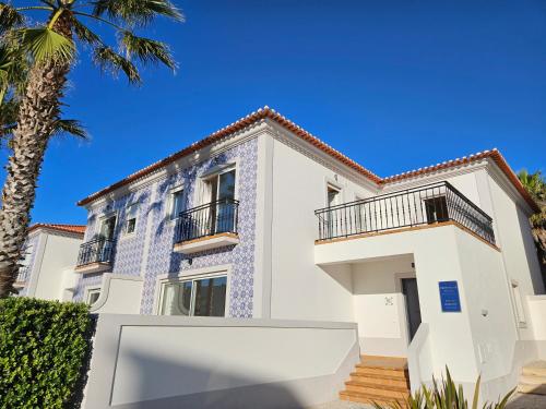 a white house with blue tile on the facade at Praia D'el Rey A1 - Golf & Beach in Óbidos