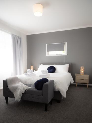 a white bedroom with a bed and a couch at House in Palmerston North, New Zealand in Palmerston North