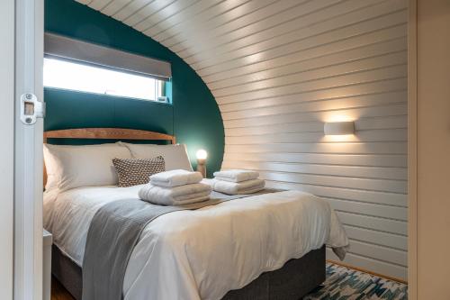 a bedroom with a bed with towels on it at Sustainable 2 Bedroom Pod on Old Chalford Farm! in Enstone