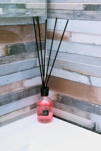 a red vase with sticks in it next to a wall at B&B REVOLUTION BED e BREAKFAST in Caserta