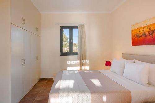 a bedroom with a large white bed with a window at Saluto by Vintage Travel in Spartia
