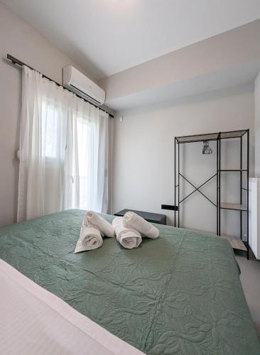 a bedroom with a bed with two towels on it at Acropolis view 3BD penthouse next to tram and port in Piraeus