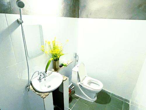 ein Badezimmer mit einer weißen Toilette und einem Waschbecken in der Unterkunft huy mán bungalow in Ha Giang