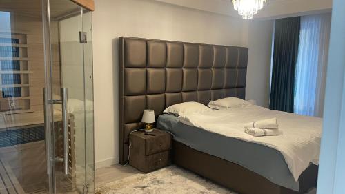 a bed with a large padded headboard in a bedroom at Velvet by Poiana Brasov in Poiana Brasov