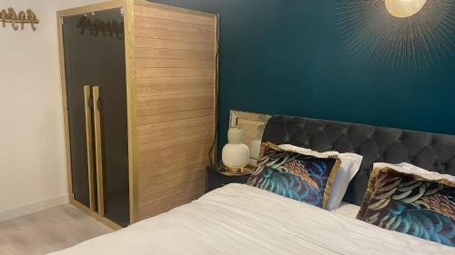 a bedroom with a bed and a blue wall at Velvet by Poiana Brasov in Poiana Brasov