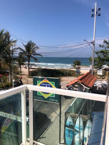 a view of the beach from a balcony with surfboards at Felicidade in sea front in Saquarema