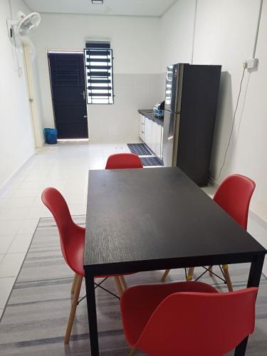 a dining room with a table and red chairs at Seroja Guesthouse Gambang in Gambang