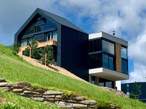 a black house on top of a hill at Apartment in Krkono e near Ski Slopes in Pec pod Snezkou