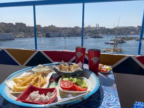 a tray of food on a table with a view of the water at Mostafa Jamaica guesthouse in Aswan
