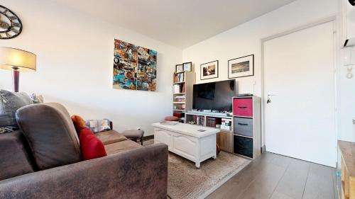 un salon avec un canapé et une télévision dans l'établissement ARCACHON PLAGE Centrale, à Arcachon
