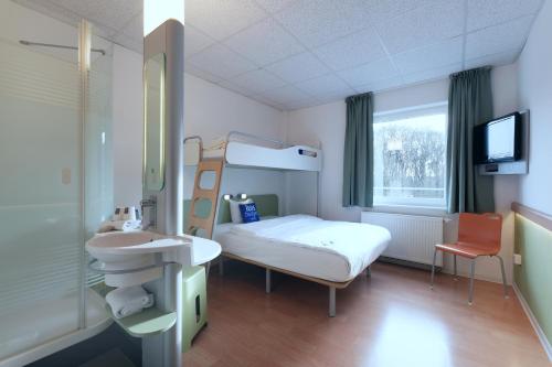 a hospital room with a bed and a sink at ibis budget Hotel BONN SÜD Königswinter in Königswinter