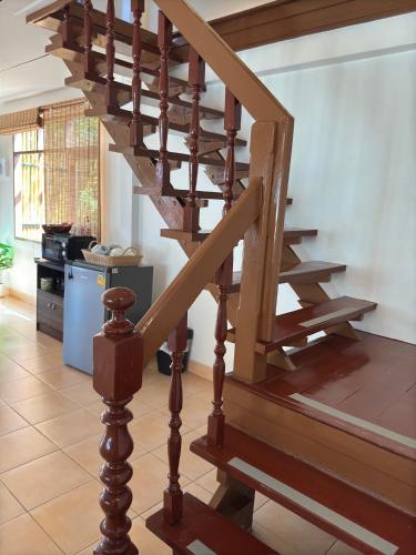 a wooden spiral staircase in a house with a kitchen at Aimei Bang Saray in Bang Sare