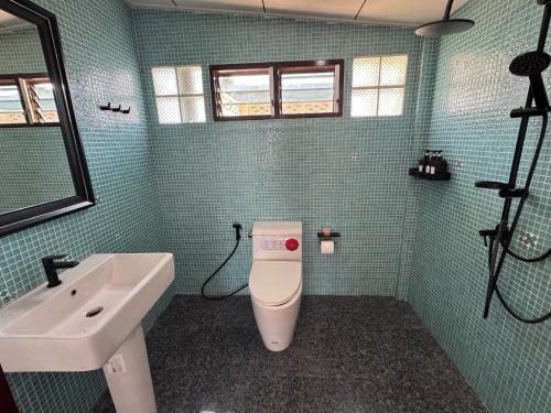 a bathroom with a white toilet and a sink at Aimei Bang Saray in Bang Sare