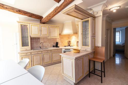 une grande cuisine avec des placards en bois et une table dans l'établissement Appartement du Couvent, à Narbonne