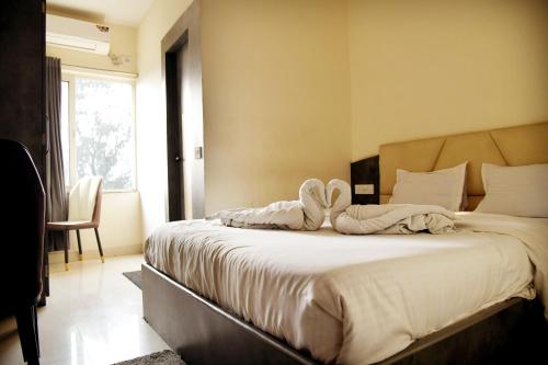 a bedroom with a large bed with white sheets at Hotel M Plaza Dhulagarh in Dhulagari