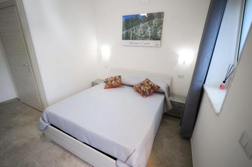 a bedroom with a white bed with two pillows on it at B&B REVOLUTION BED e BREAKFAST in Caserta