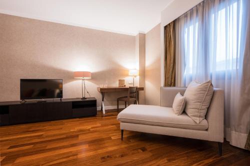 a living room with a couch and a television at Castilla Termal Olmedo in Olmedo