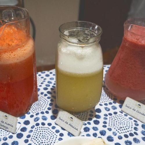 a table with two jars of juice and a plate of food at Pousada Tapajos Bonito in Bonito