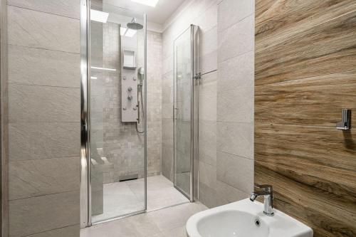 a bathroom with a shower and a white sink at Novos Luxury Suites in Bucharest