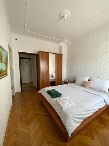 a large white bed in a room with wooden floors at Hotel Vlasina - Vlasinsko jezero in Lujinska Mala