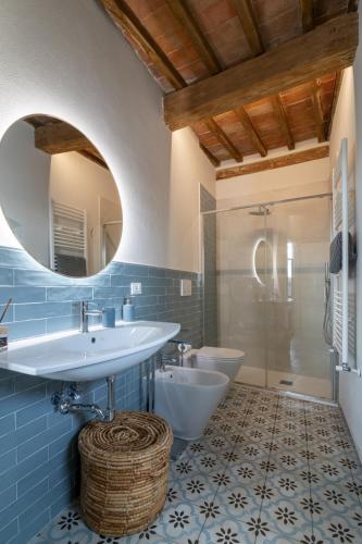 a bathroom with a sink and a toilet and a mirror at Palazzo Luparelli Boutique Apartment in Colle di Val d'Elsa