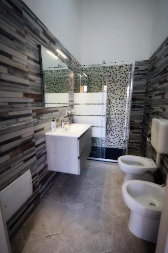 a bathroom with a sink and two toilets at B&B REVOLUTION BED e BREAKFAST in Caserta