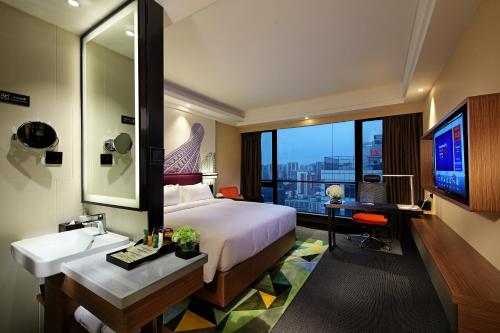 a bedroom with a bed and a sink and a desk at Hampton by Hilton Guangzhou Zhujiang New Town in Guangzhou