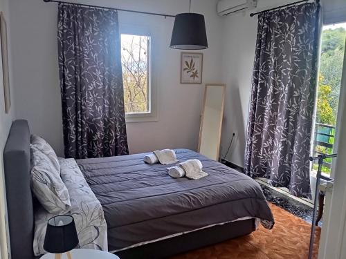a bedroom with a bed with two towels on it at Serene Country House (near Ancient Tiryns) in Nafplio
