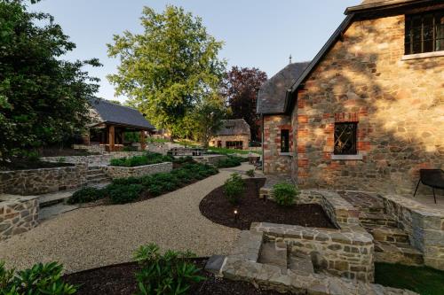 a stone house with a garden in front of it at Le Temps de Vivre Chimay - Ardennen in Momignies