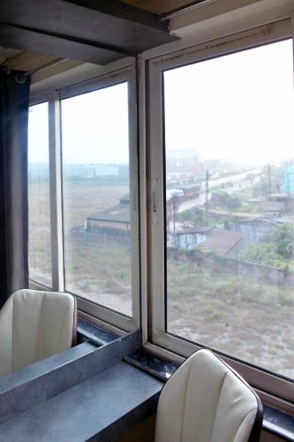 two chairs sitting in a train with two windows at Hotel M Plaza Dhulagarh in Dhulagari