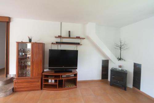 a living room with a television on a wooden table at acasadeblanco in Teo