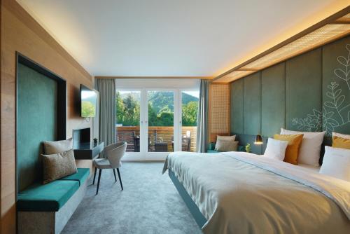 a bedroom with a large bed and a large window at Das Tegernsee in Tegernsee