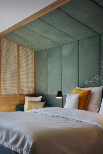 a bedroom with a large bed and a green wall at Das Tegernsee in Tegernsee