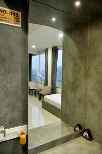 a mirror in a room with a bed and a bedroom at Hotel M Plaza Dhulagarh in Dhulagari