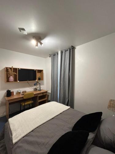 une chambre avec un lit et un bureau avec un ordinateur dans l'établissement Studio in Issy Les Moulineaux, à Issy-les-Moulineaux