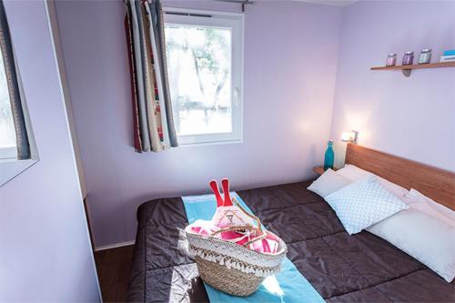 - une petite chambre avec un lit et une fenêtre dans l'établissement Mobil Home 2 chambre 4 à 6 personne en camping 4 étoiles, à Torreilles