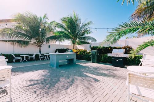 a patio with a ping pong table and palm trees at Arubas Life 212 in Noord