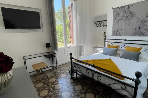 a bedroom with a bed and a tv on a wall at Suite San Michele – Eleganza vicino alle Mura in Lucca
