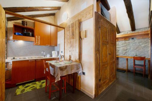 a kitchen with a table and some chairs in a room at Arthemisia - Rhêmes-Notre-Dame in Rhêmes-Notre-Dame