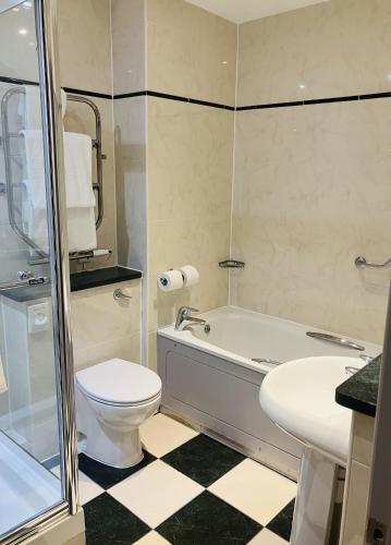 a bathroom with a toilet and a tub and a sink at Macdonald Cardrona Hotel, Golf & Spa in Peebles