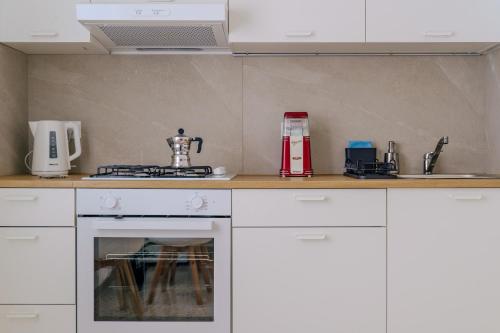 a kitchen with white cabinets and a stove top oven at Domus-Pulchra in Bari